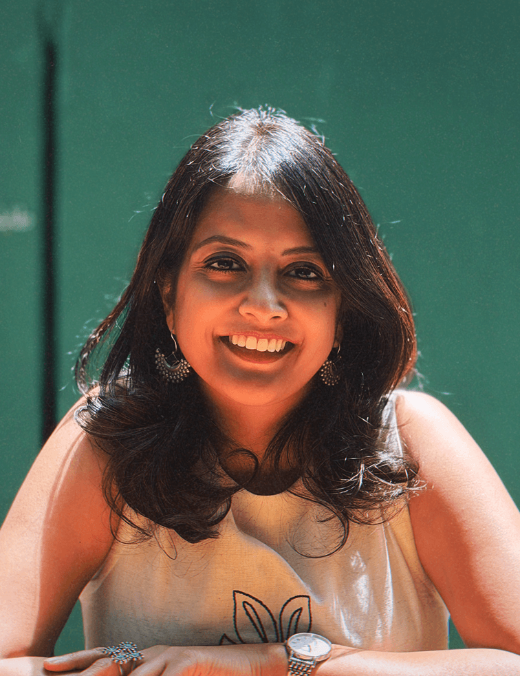 Megha Don Bosco smiling against a green background